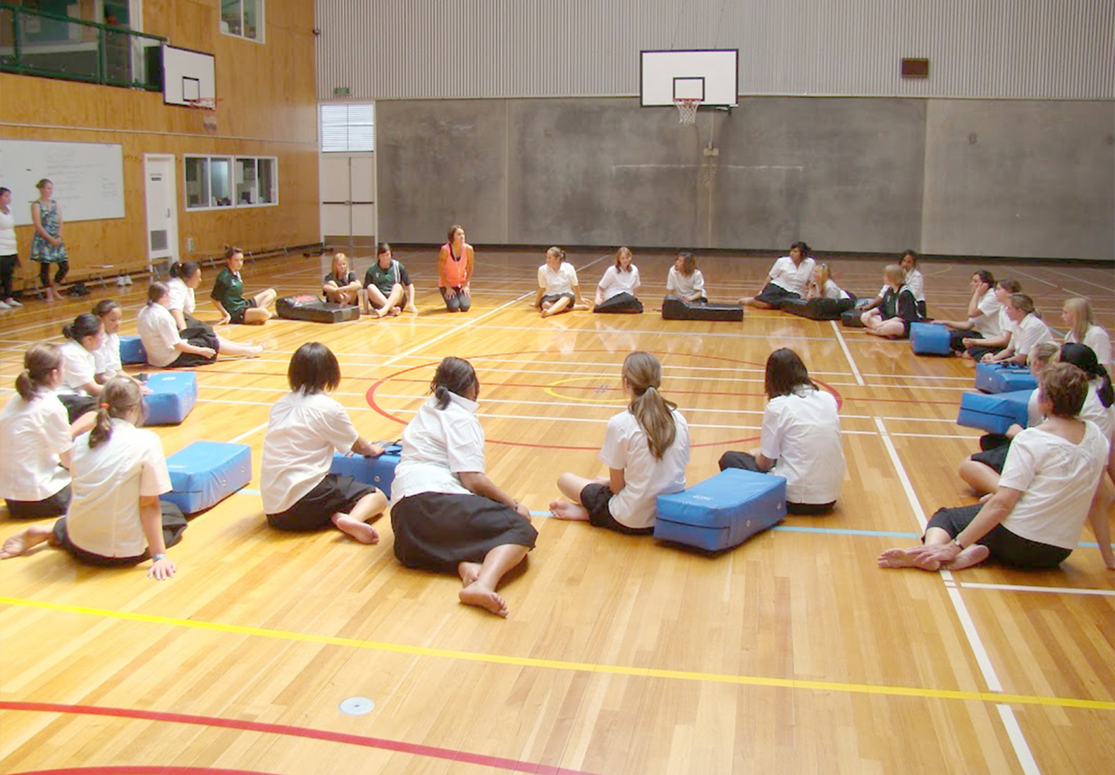 A class of girls sitting and reflecting after some Rock and Water exercises